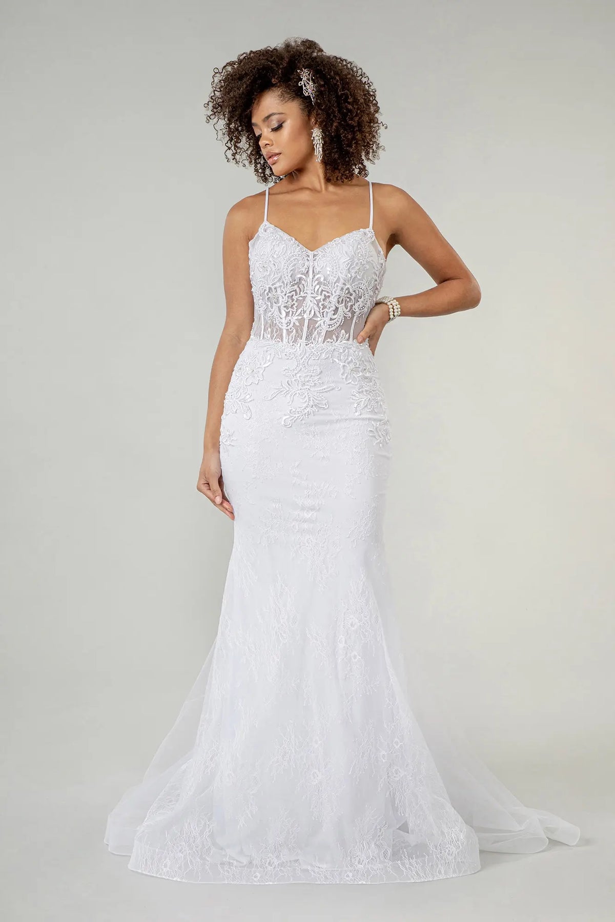 Floral lace continues over the hips into the airy hem of this white wedding gown.