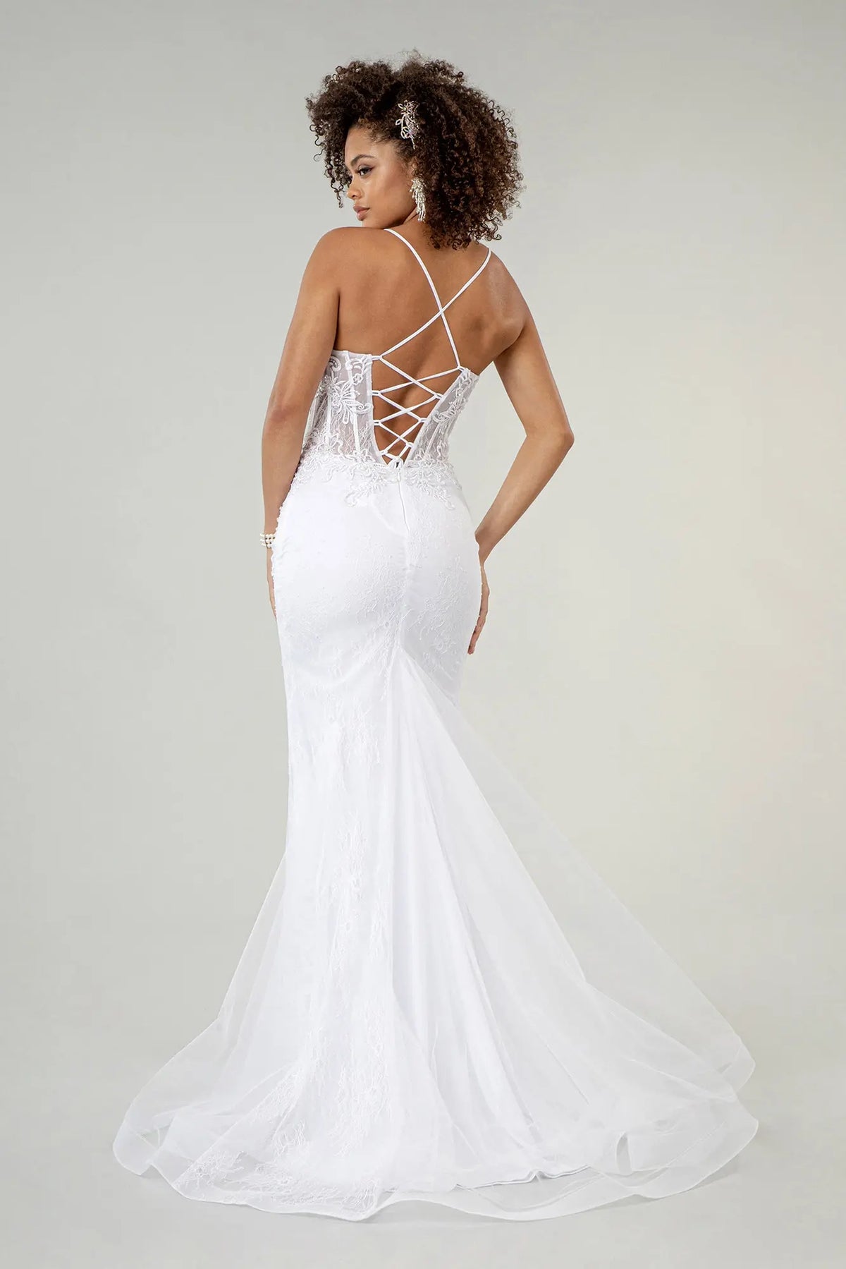 The white wedding gown's fitted back opens into a sweeping mesh mermaid skirt.