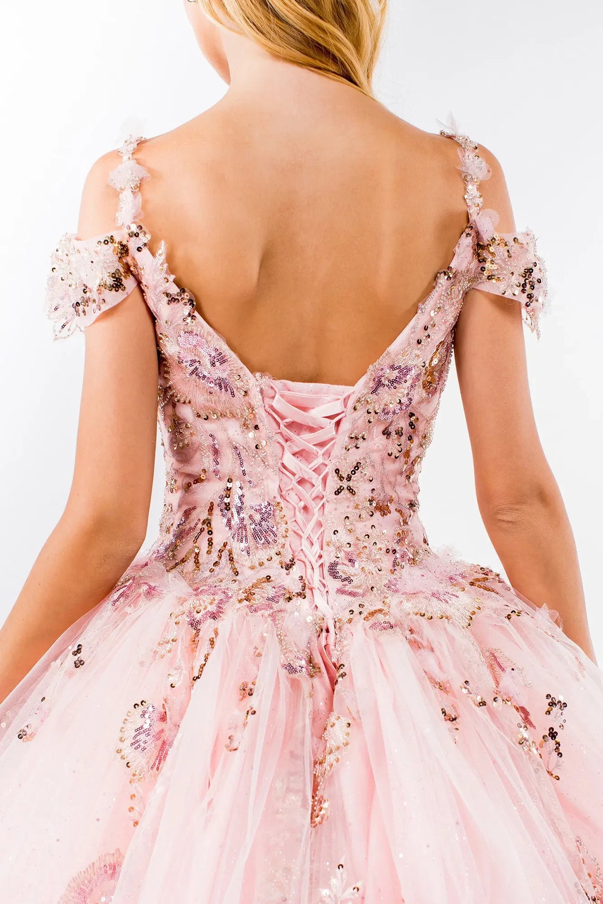 Layered skirt showcases the Blush quinceañera ball gown with glitter embroidery.
