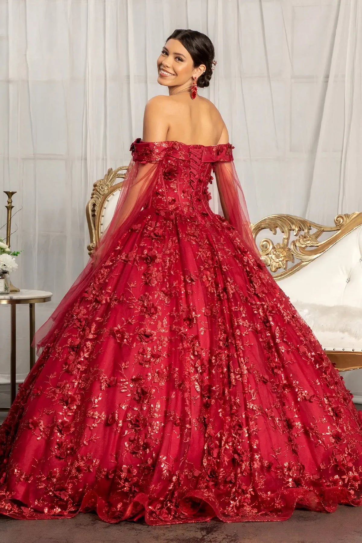 Bodice close-up highlights the Burgundy quinceañera ball gown with draped shoulder mesh.
