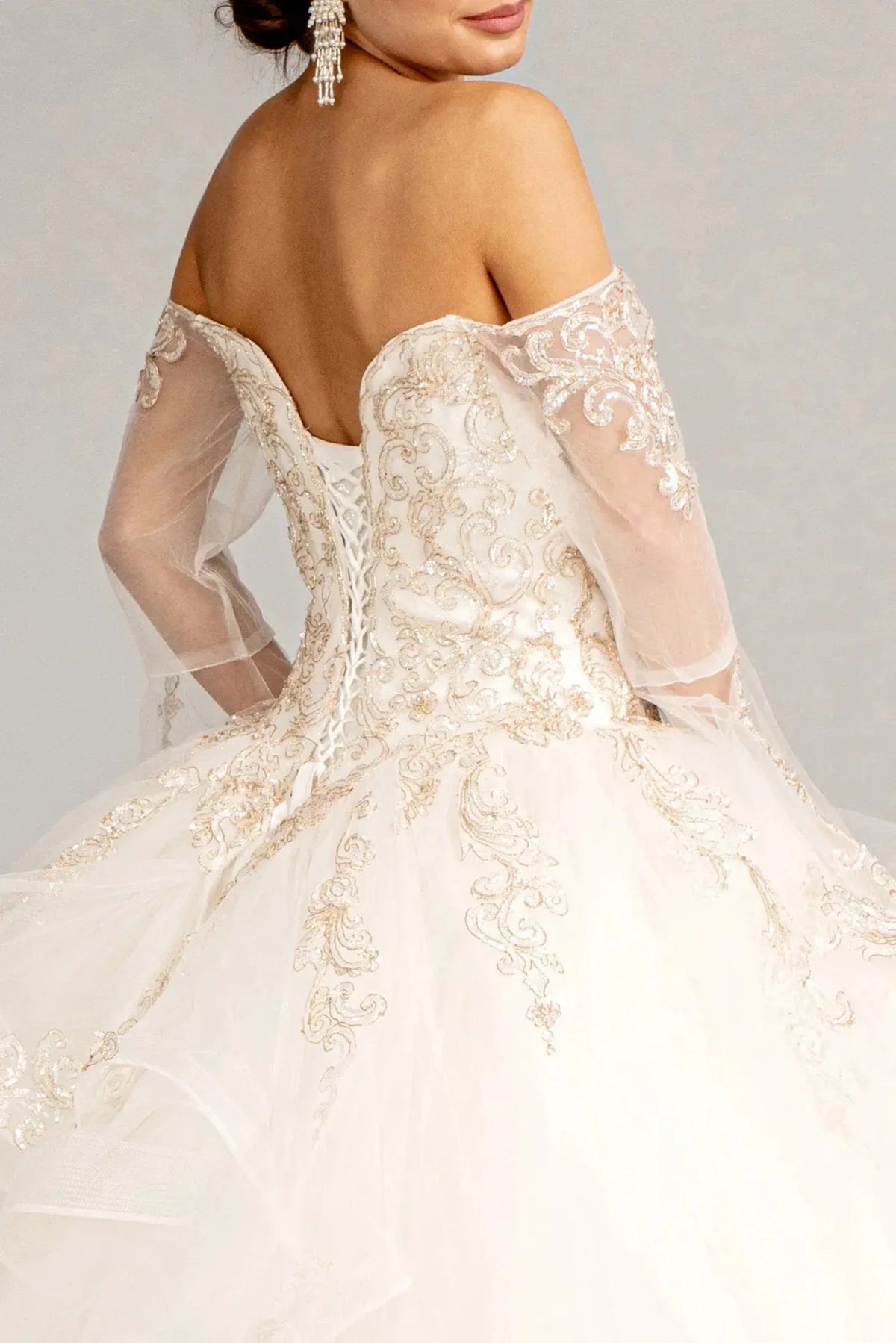 Embroidered details frame the Off White quinceañera ball gown with long mesh sleeves.