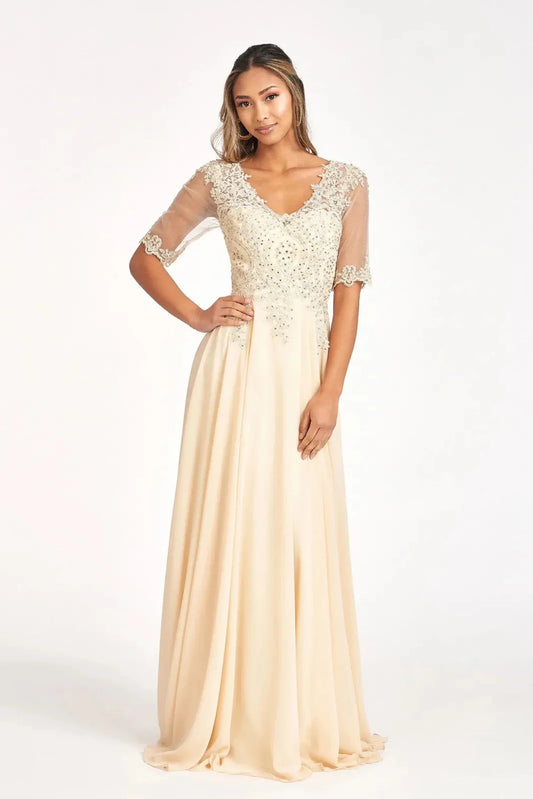 Bodice close-up highlights champagne chiffon a-line mother of the bride dress with v-neckline.