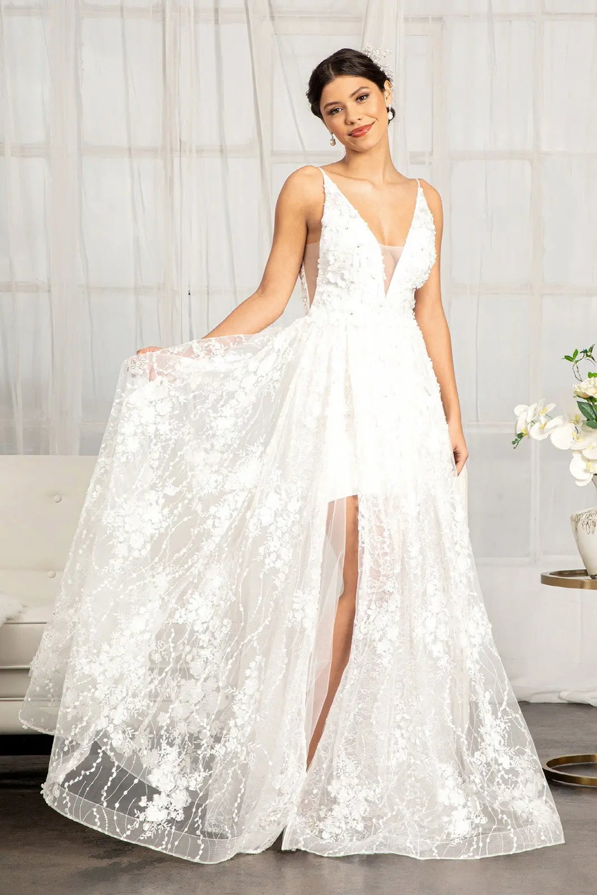 A floral mesh overlay frames the front slit of this white wedding gown.