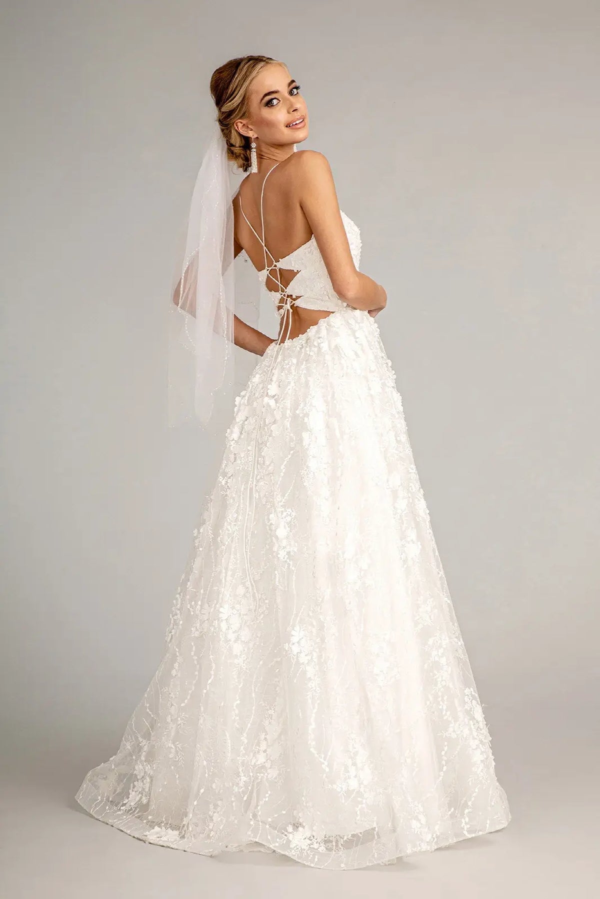 Cutout panels frame the tied corset back on the white wedding gown.