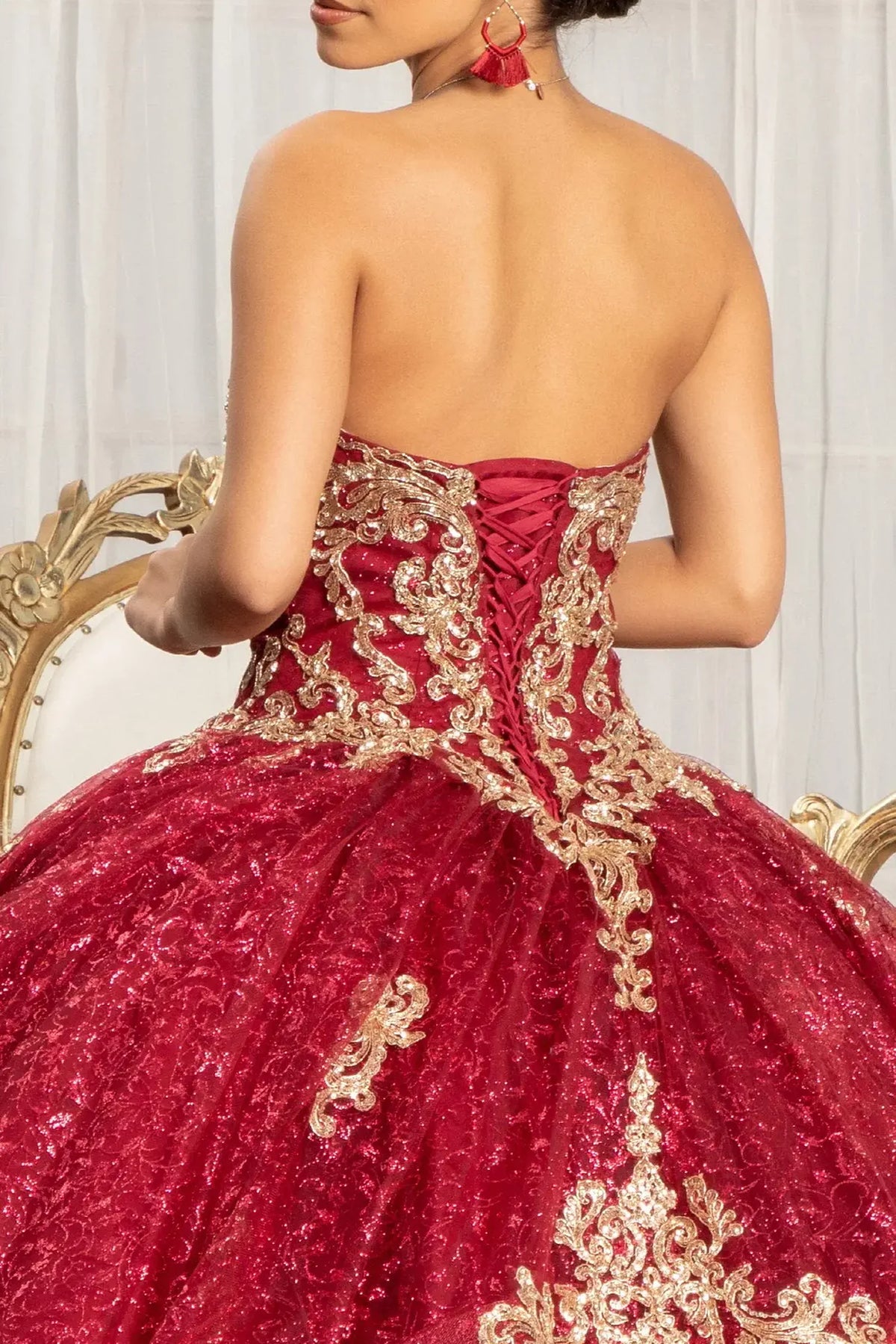 Embroidered details frame the Burgundy quinceañera ball gown with sequin pattern.