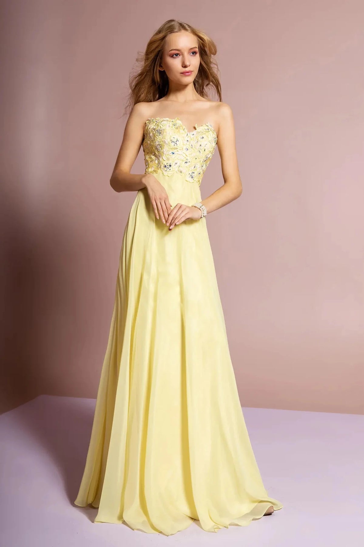 Full-length front view shows beaded strapless styling on the Yellow prom evening dress.