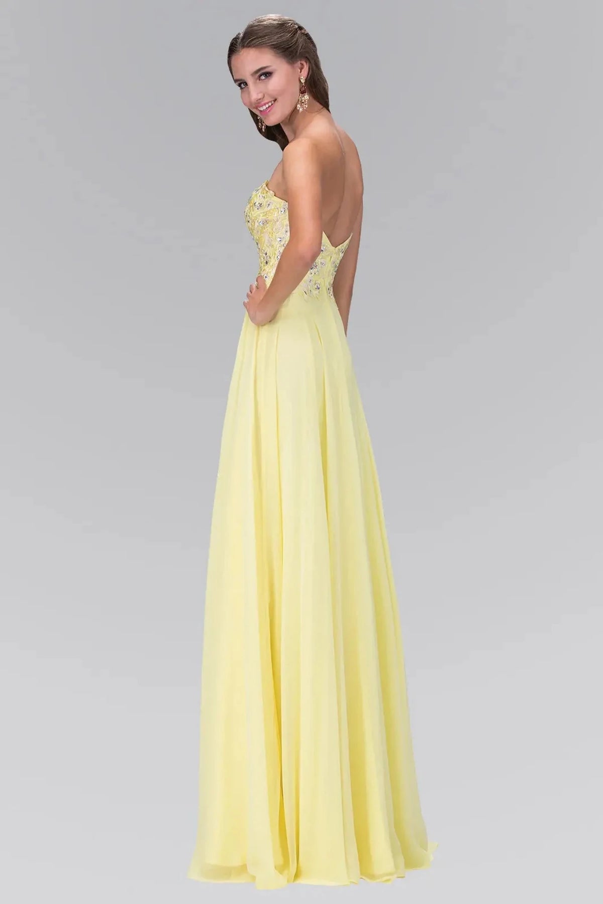 Rear view highlights the open back of the Yellow prom evening dress.