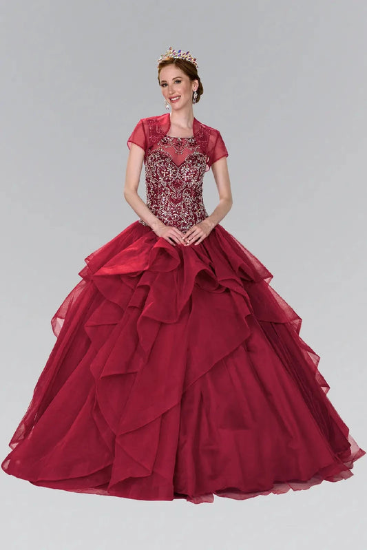 The Burgundy quinceañera ball gown appears head to toe with a sheer bolero over a jeweled bodice and tiered skirt.