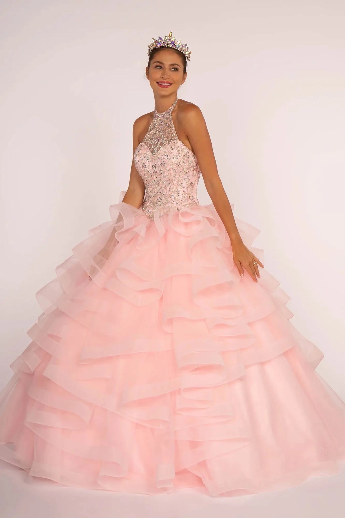 The Baby Pink quinceañera ball gown appears head to toe with a sparkling halter bodice and tiered baby-pink tulle skirt.