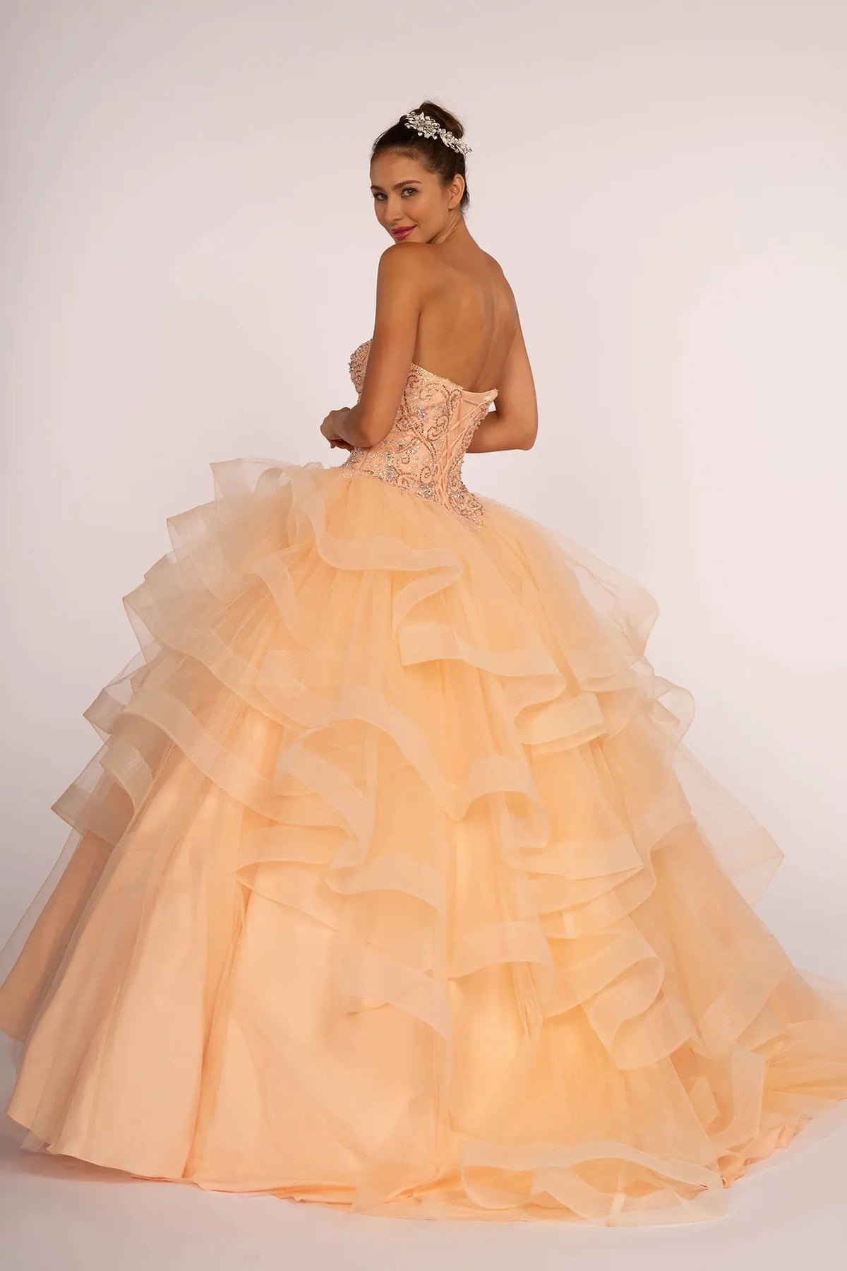 Lace-up back reveals the Peach quinceañera ball gown with lace-up back and ruffled tulle skirt.