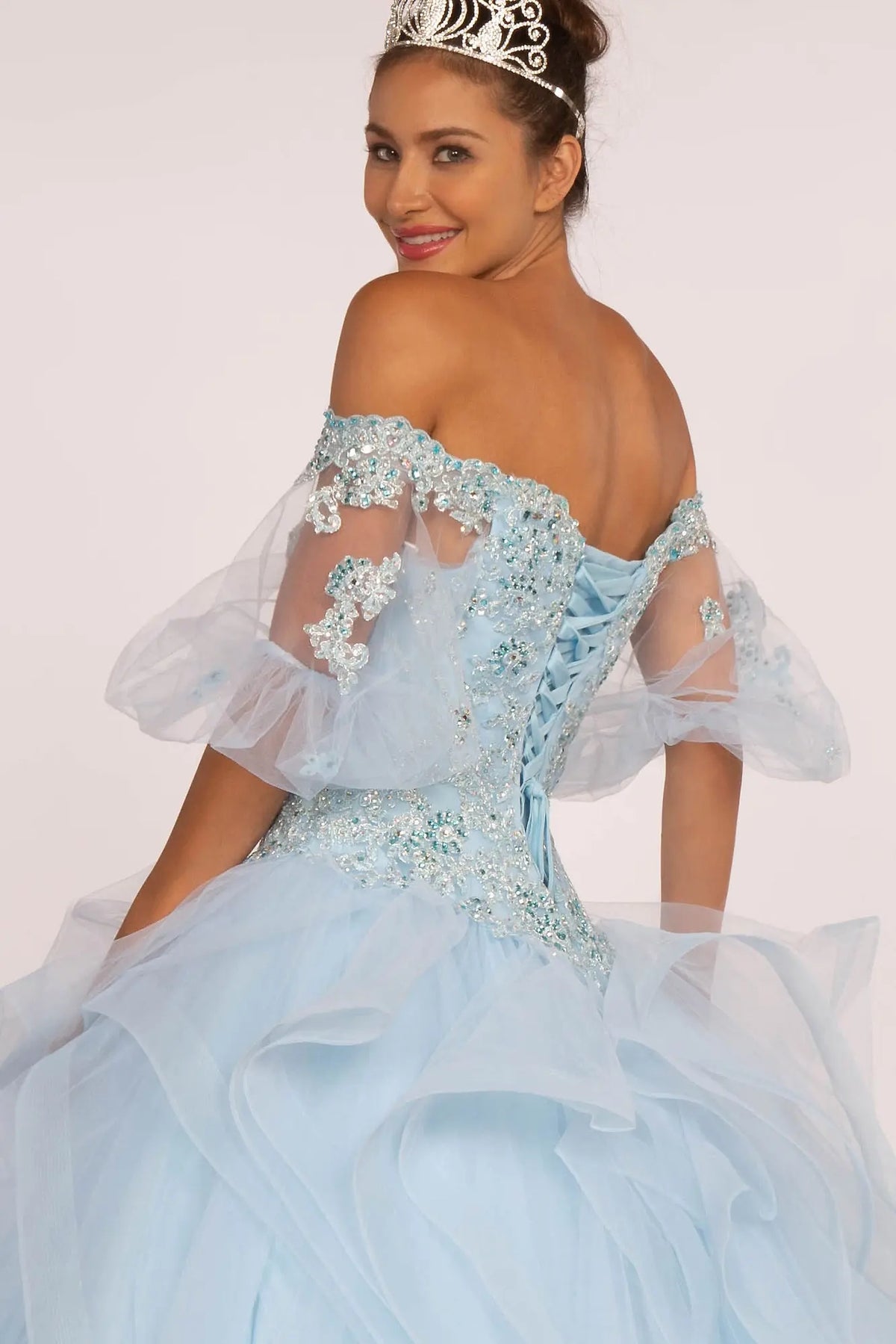 Embroidered details frame the Baby Blue quinceañera ball gown with layered tulle skirt.
