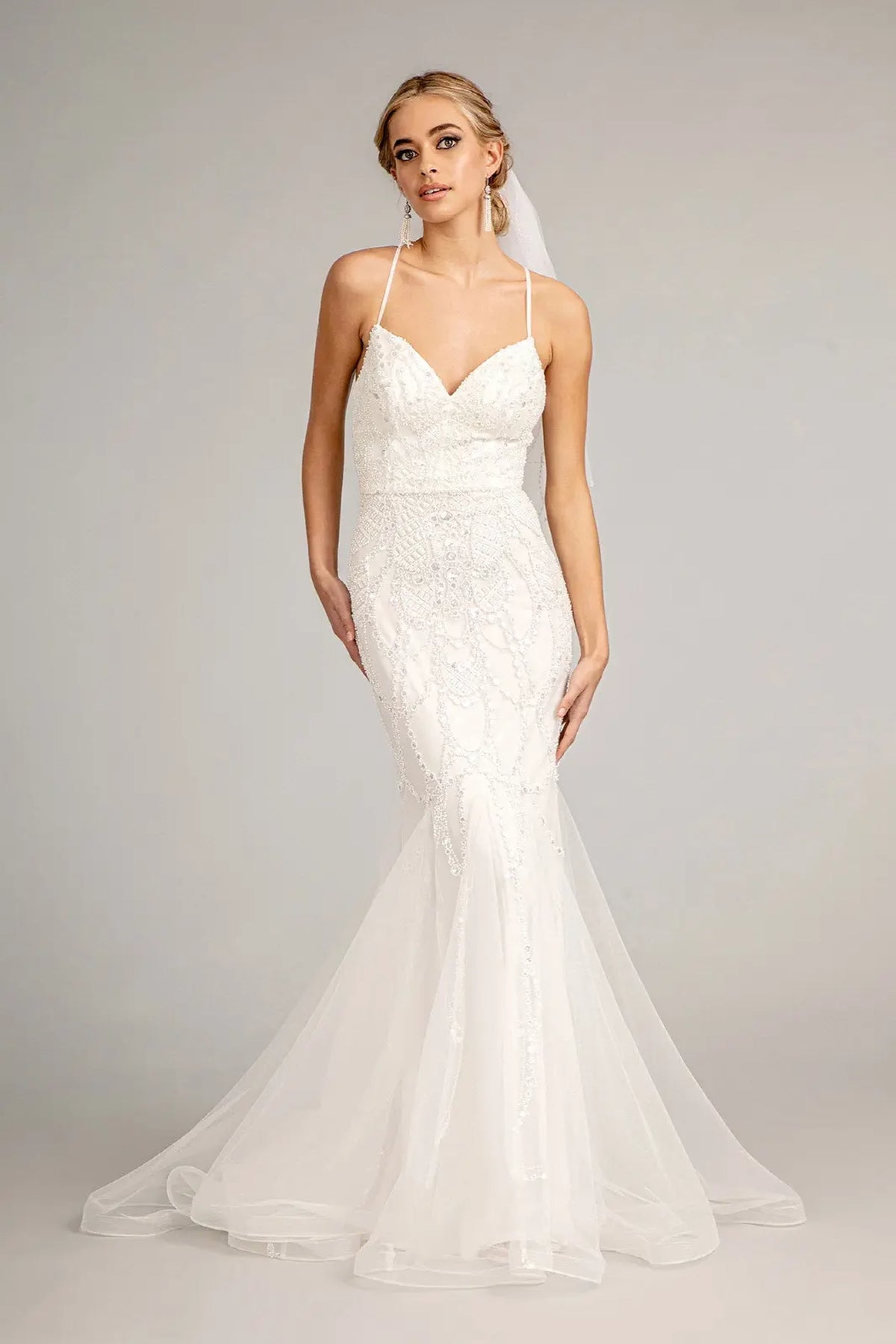 The fitted lace silhouette opens into a mesh mermaid hem on this ivory wedding gown.