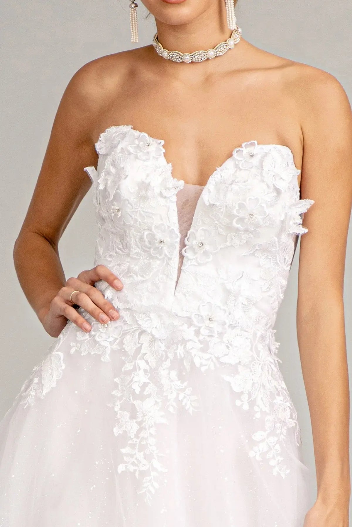 White wedding gown with raised floral appliques across a strapless illusion sweetheart bodice.
