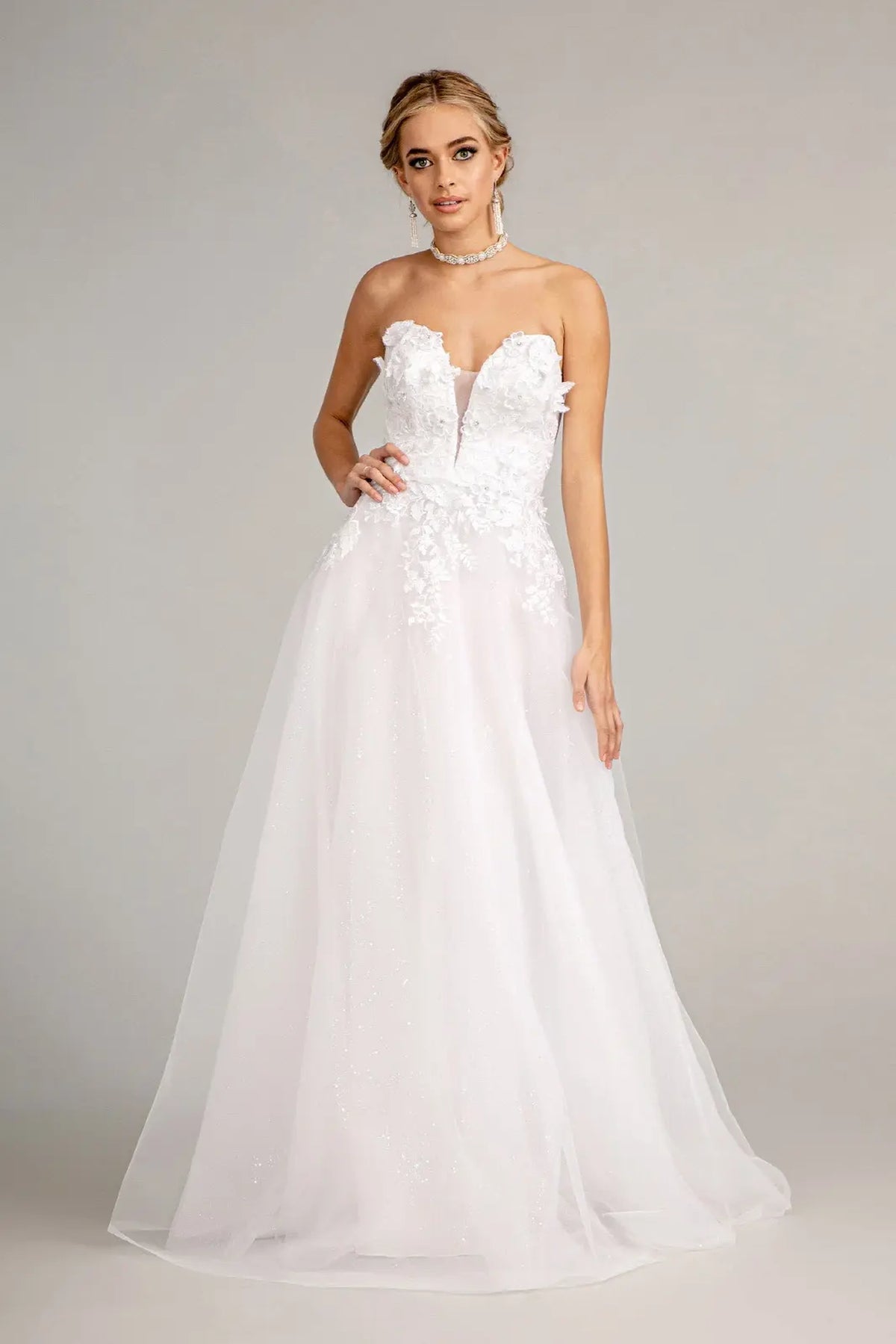 Glittering mesh layers form the full A-line skirt of this white wedding gown.