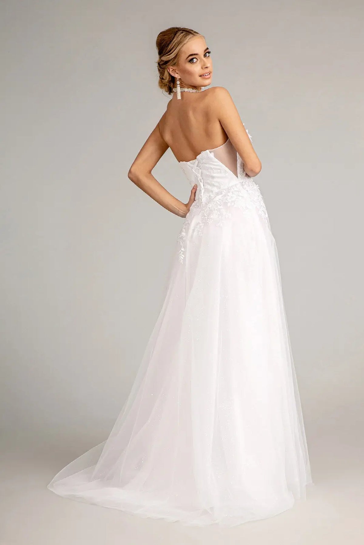 An open corset back leads into the flowing skirt of the white wedding gown.