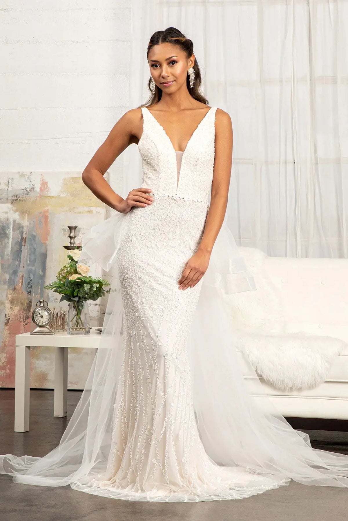 Flowing mesh surrounds the fitted mermaid skirt of this Ivory/Champagne wedding gown.