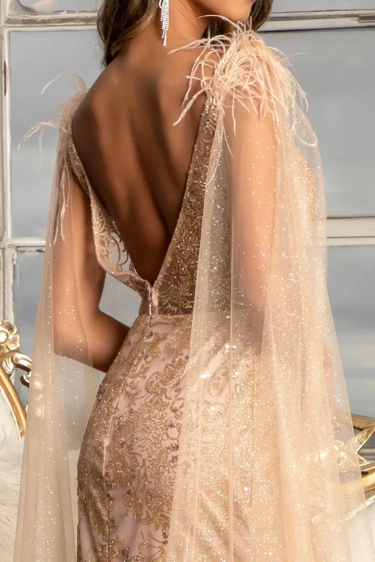 Rose Gold mother of the bride dress with a feather shoulder above the open back