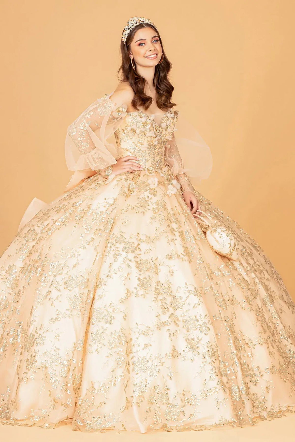 Embroidered details frame the Gold quinceañera ball gown with detachable back bow.