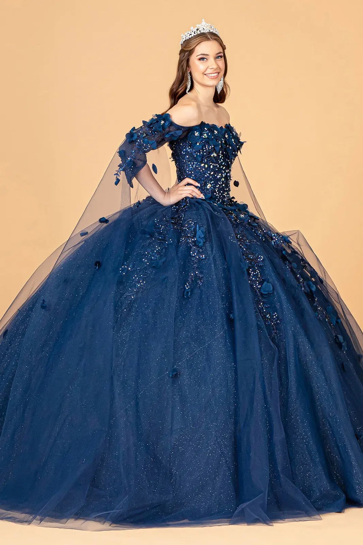 Embroidered details frame the Navy quinceañera ball gown with shoulder mesh drapes.