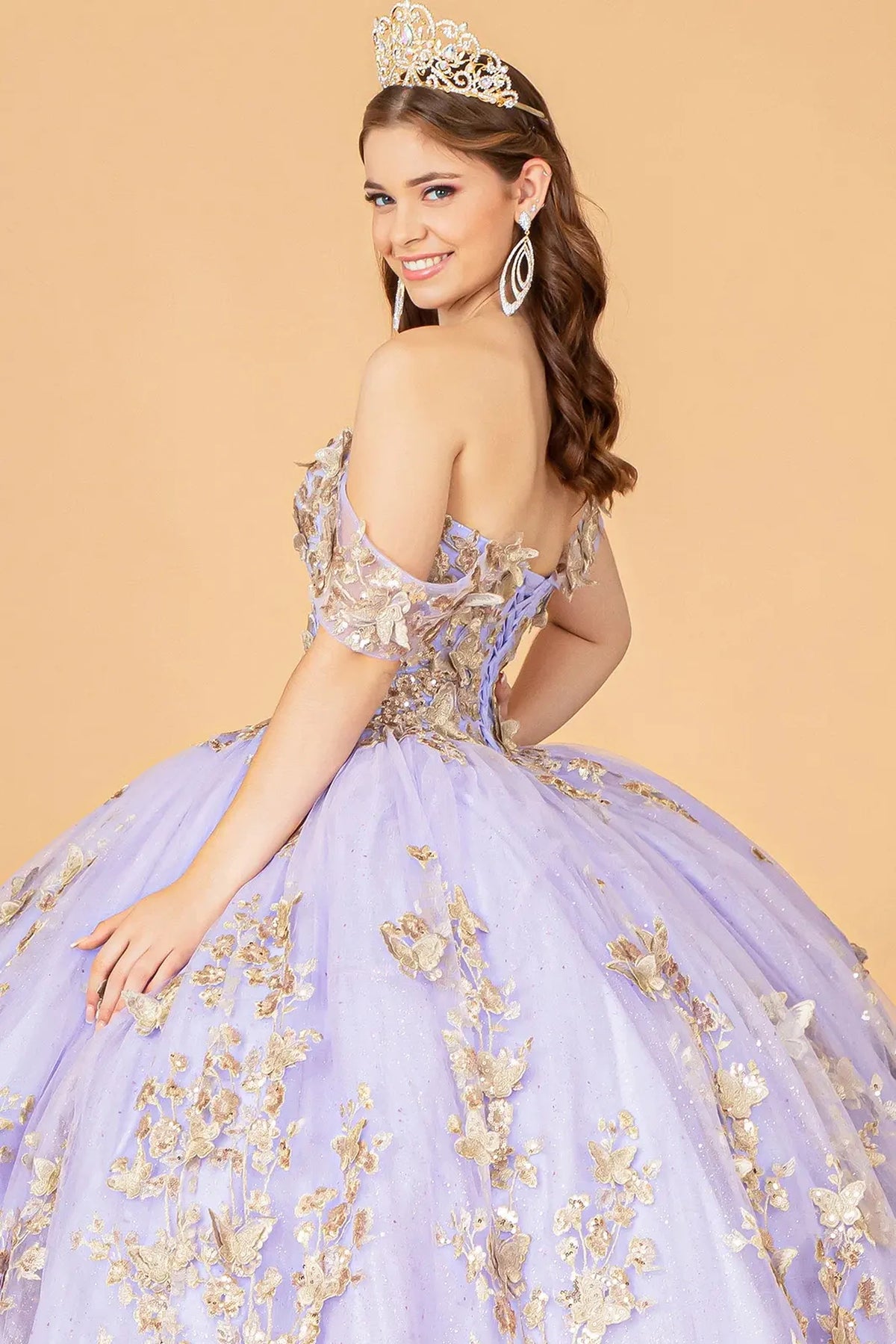 Layered skirt showcases the Lilac quinceañera ball gown with 3d butterfly appliqués.
