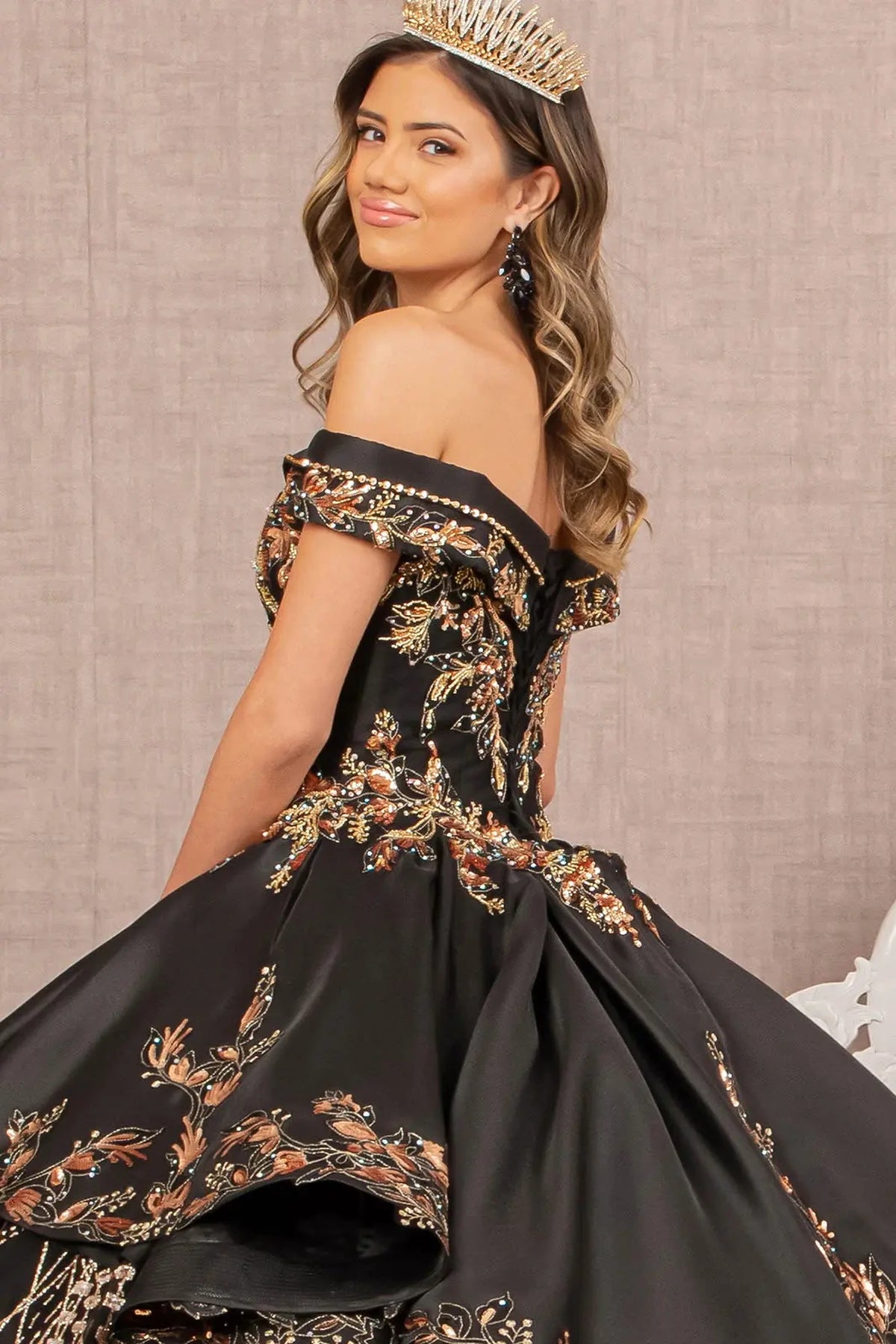 Detachable accents complete the Black/Gold quinceañera ball gown with gold embroidered train.
