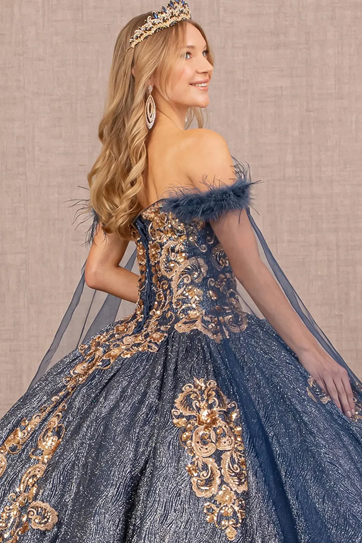 Embroidered details frame the Navy quinceañera ball gown with feather sequin detail.