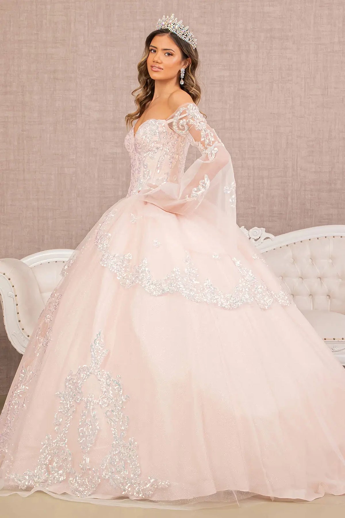 Embroidered details frame the Blush quinceañera ball gown with layered hem.