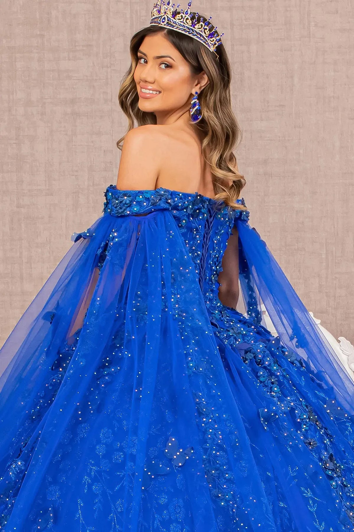 Layered skirt showcases the Royal Blue quinceañera ball gown with long mesh drapes.