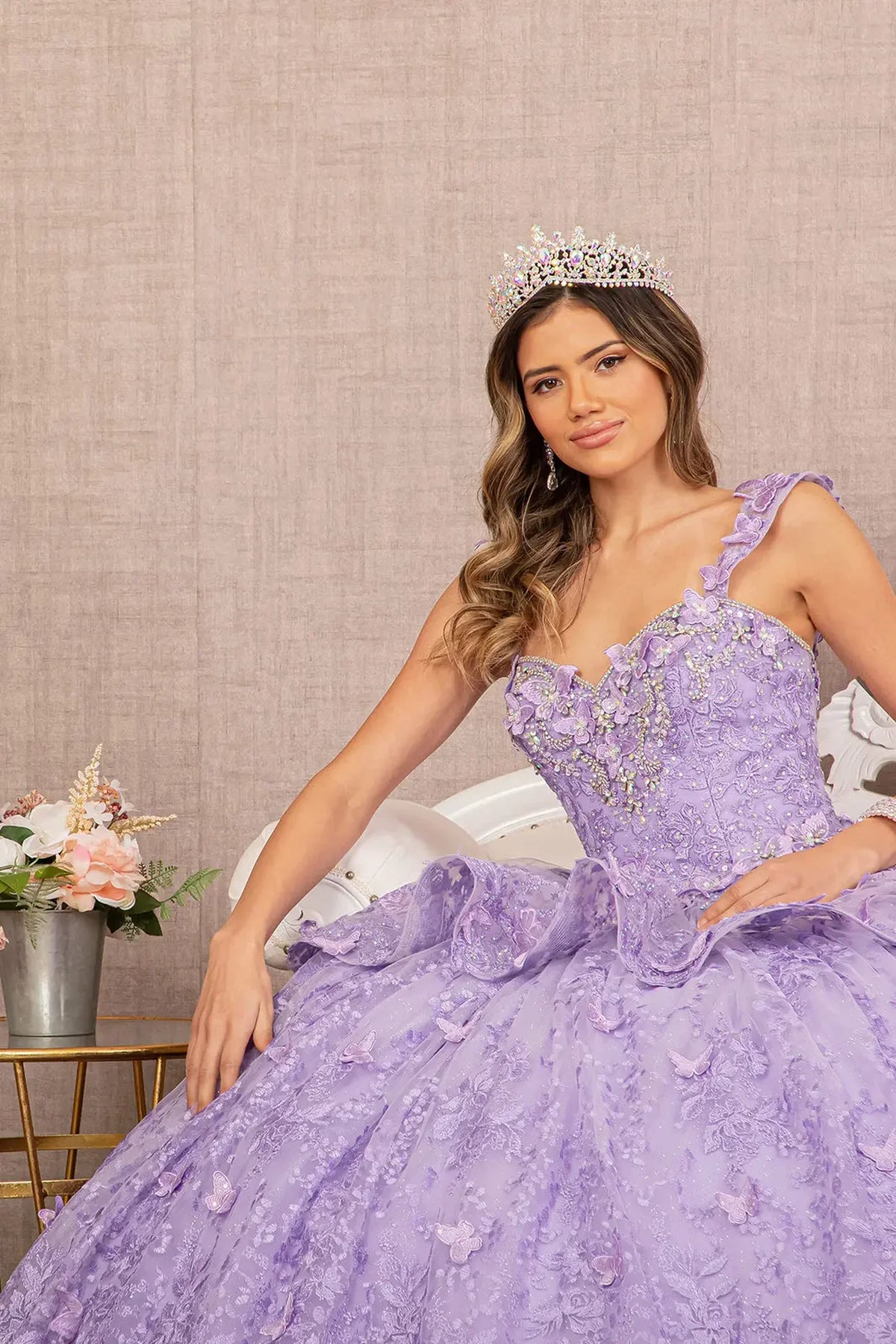 Layered skirt showcases the Lilac quinceañera ball gown with 3d butterfly appliqués.