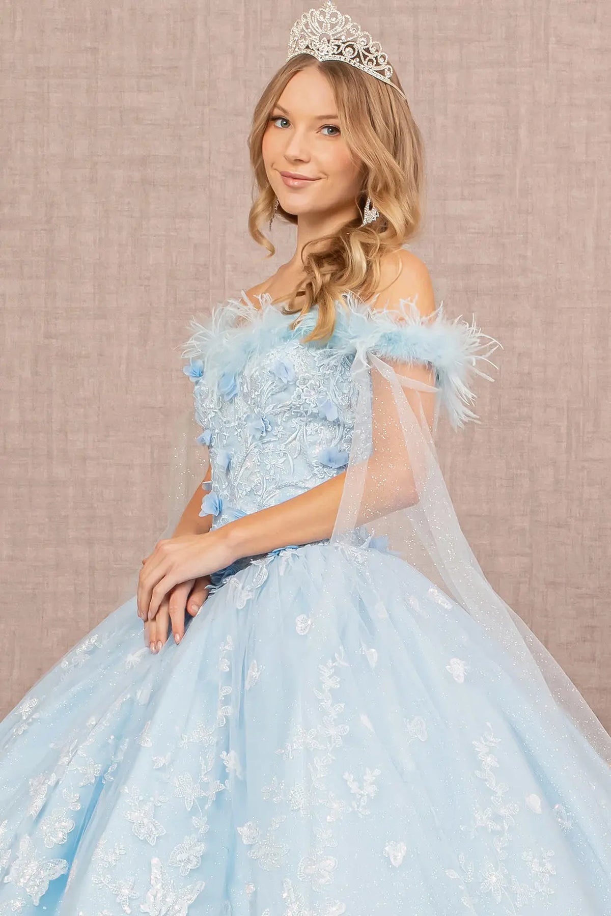 Full-length view presents the Baby Blue quinceañera ball gown with feather trim.