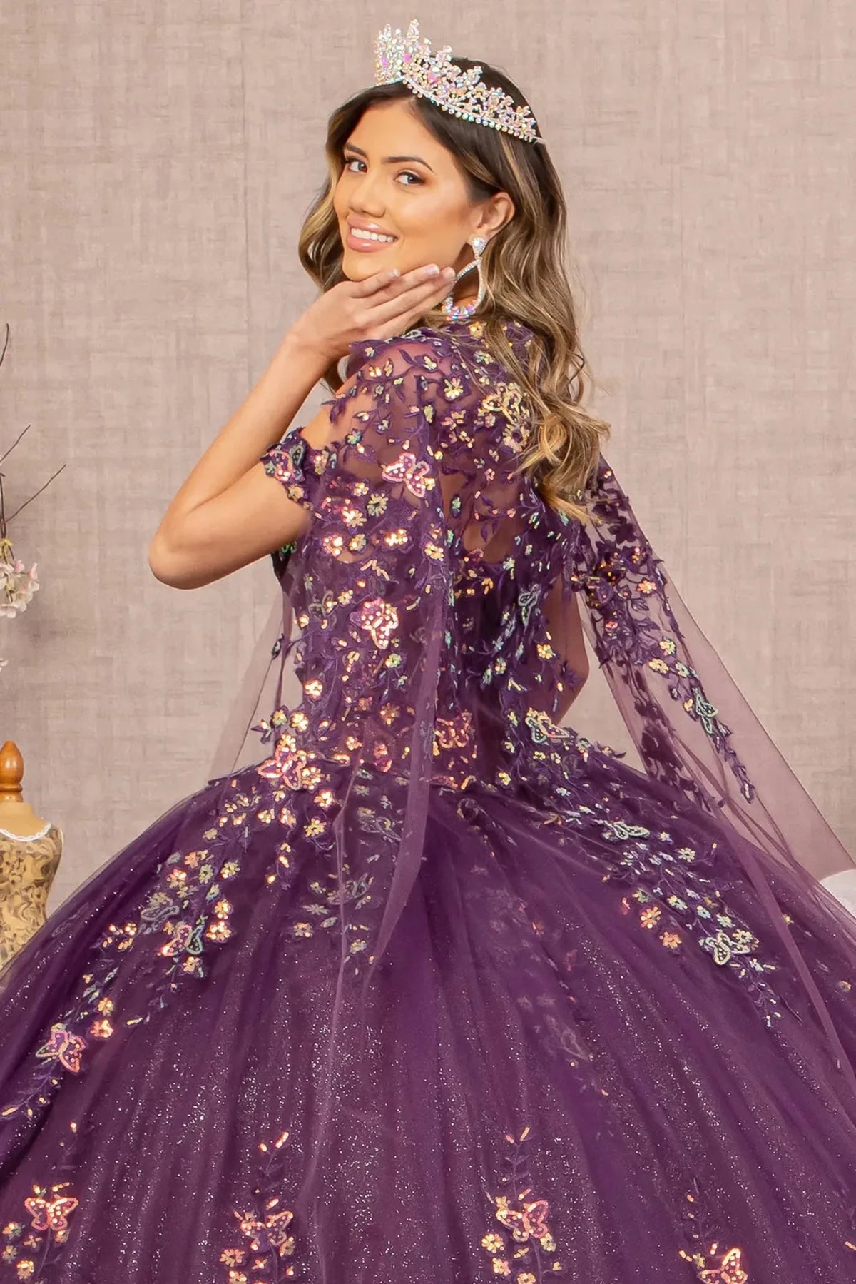 Layered skirt showcases the Purple quinceañera ball gown with 3d butterfly appliqués.