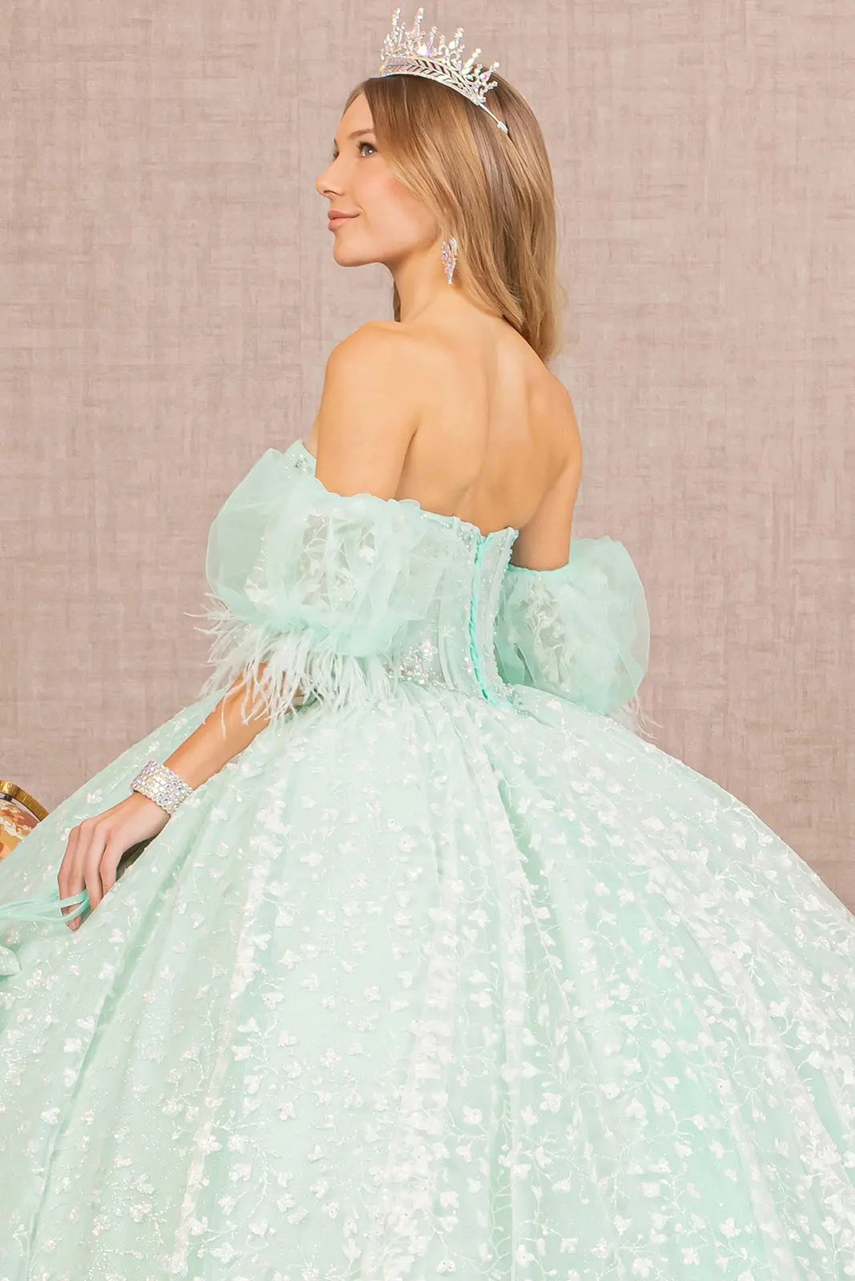 Layered skirt showcases the Mint quinceañera ball gown with detachable puff sleeves.