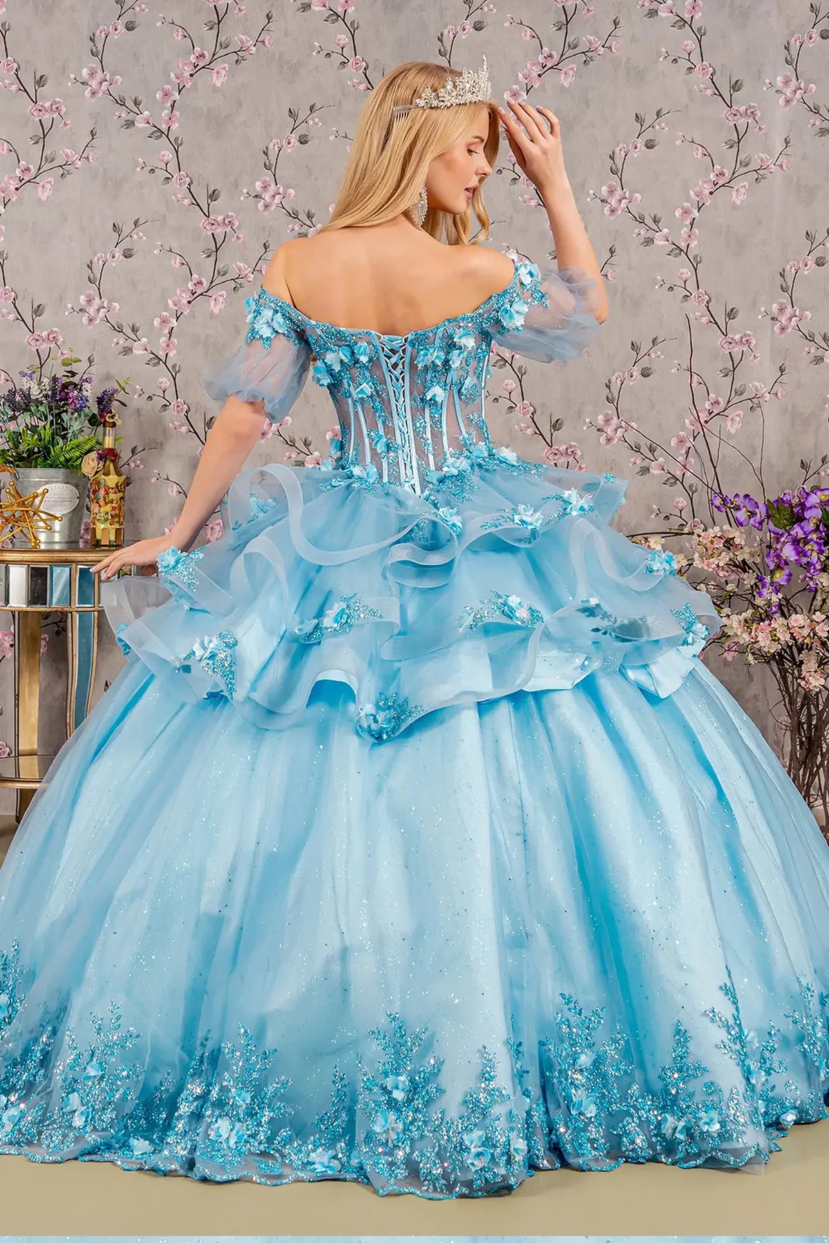 Bodice close-up highlights the Baby Blue quinceañera ball gown with 3d floral appliqués.