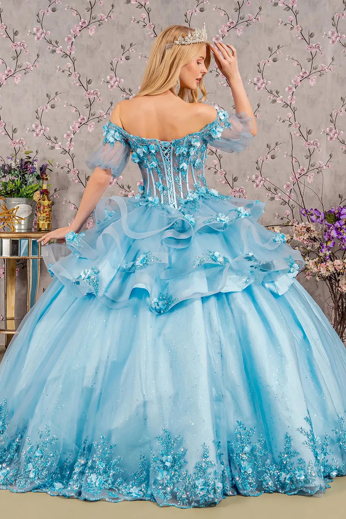 Layered skirt showcases the Baby Blue quinceañera ball gown with ruffled skirt.