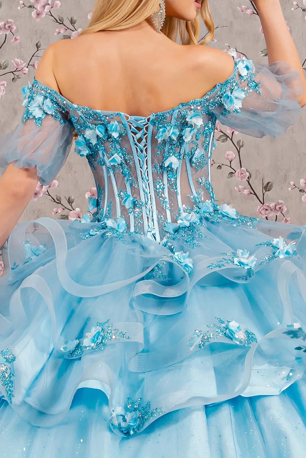 Detachable accents complete the Baby Blue quinceañera ball gown with ruffled skirt.