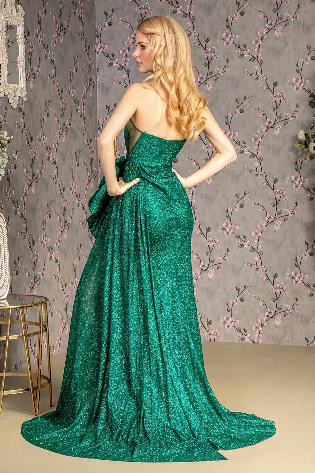 Rear view highlights the open back of the Green prom evening dress.