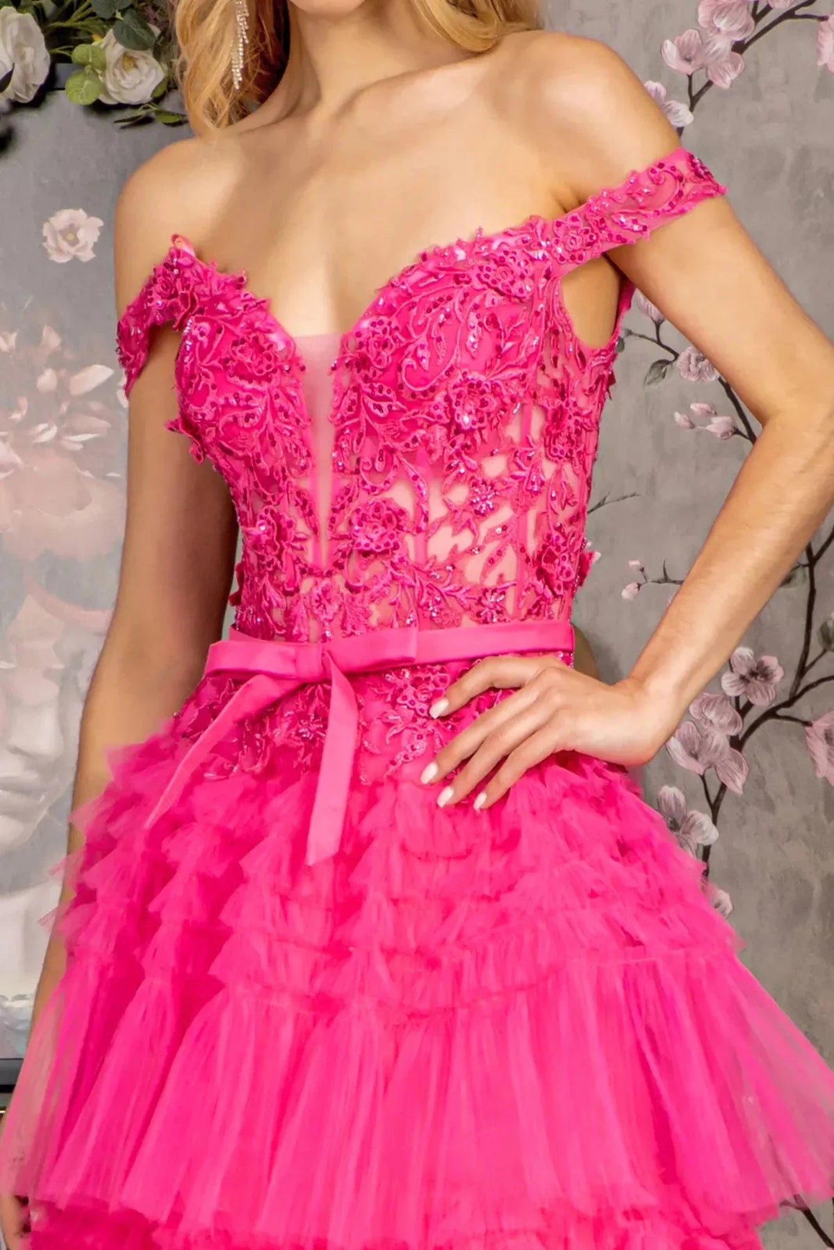 Bodice close-up reveals appliqué, beadwork, embroidery across the illusion sweetheart upper bodice of the Fuchsia prom evening dress.