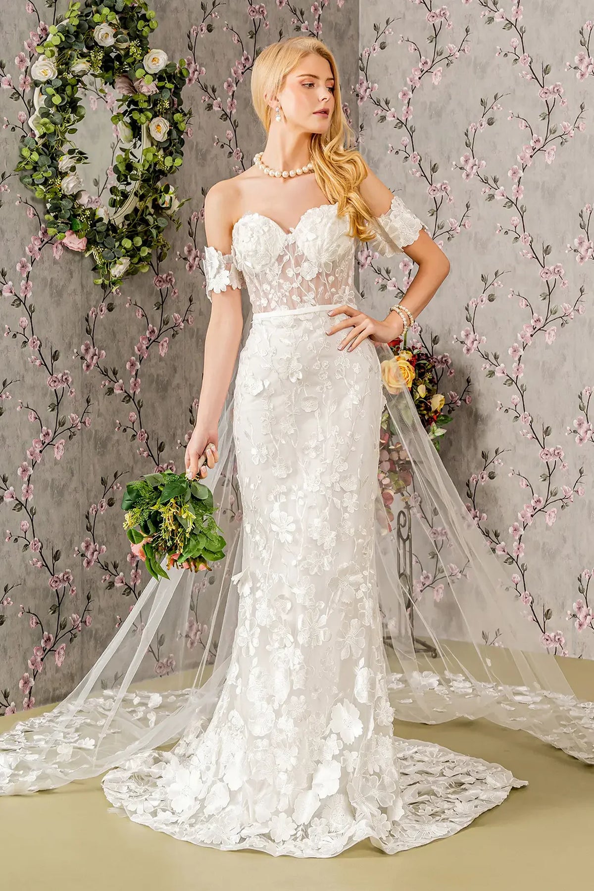 Floral embroidery follows the fitted mermaid skirt of this ivory wedding gown.