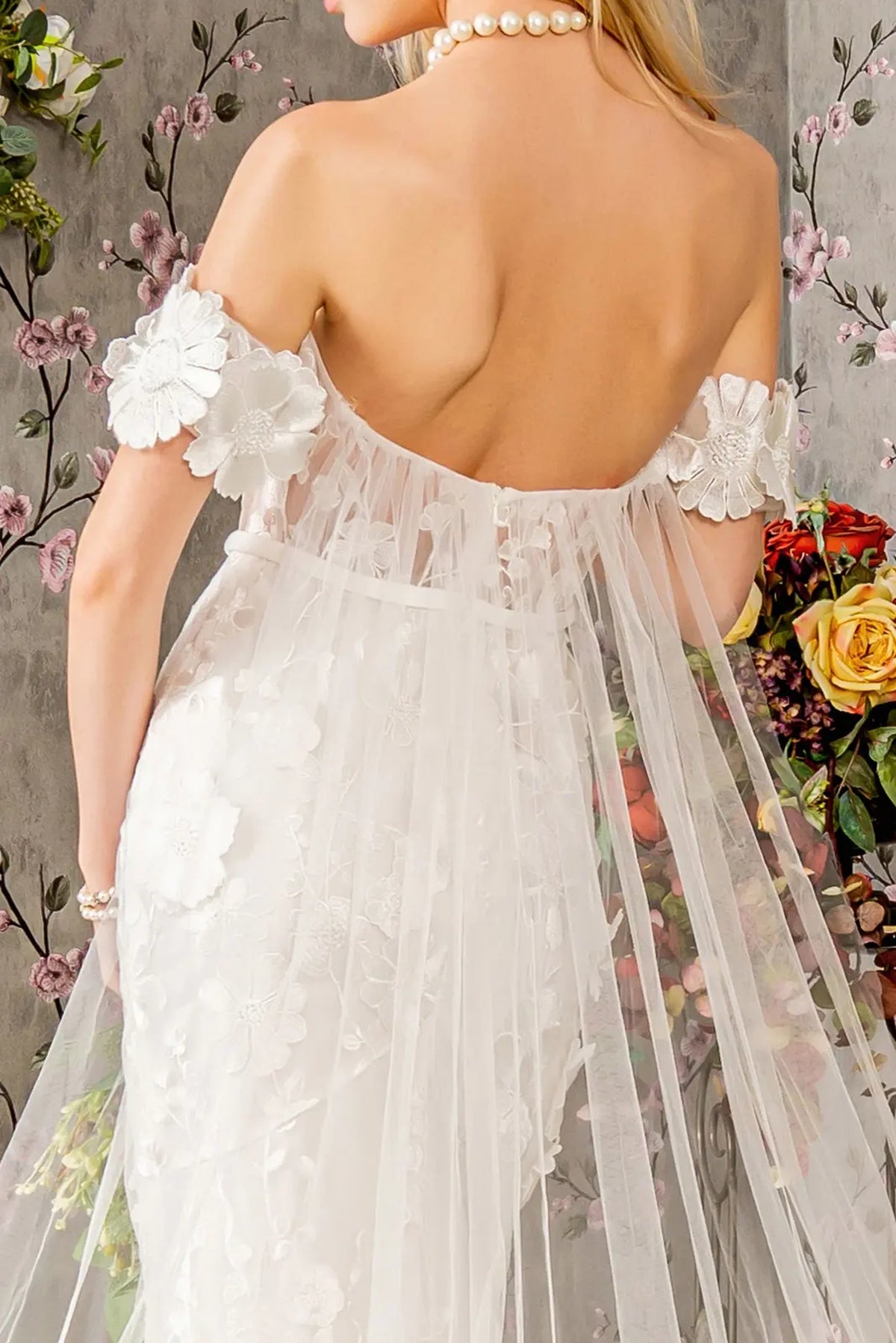 The ivory wedding gown's low back joins a softly gathered floral mesh drape.
