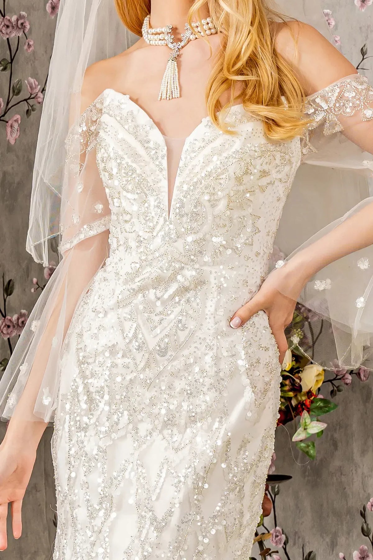 Ivory wedding gown with sparkling beadwork around its plunging illusion sweetheart neckline.