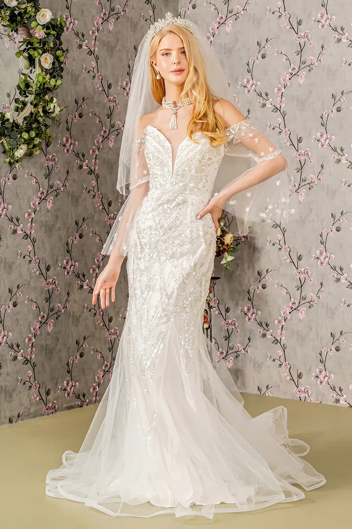A beaded mermaid silhouette and sheer sleeves define this ivory wedding gown.