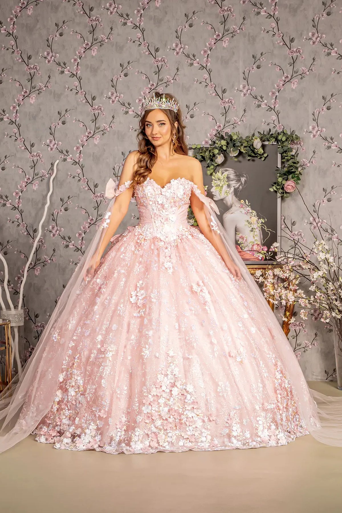 Embroidered details frame the Blush quinceañera ball gown with detachable ribbons.