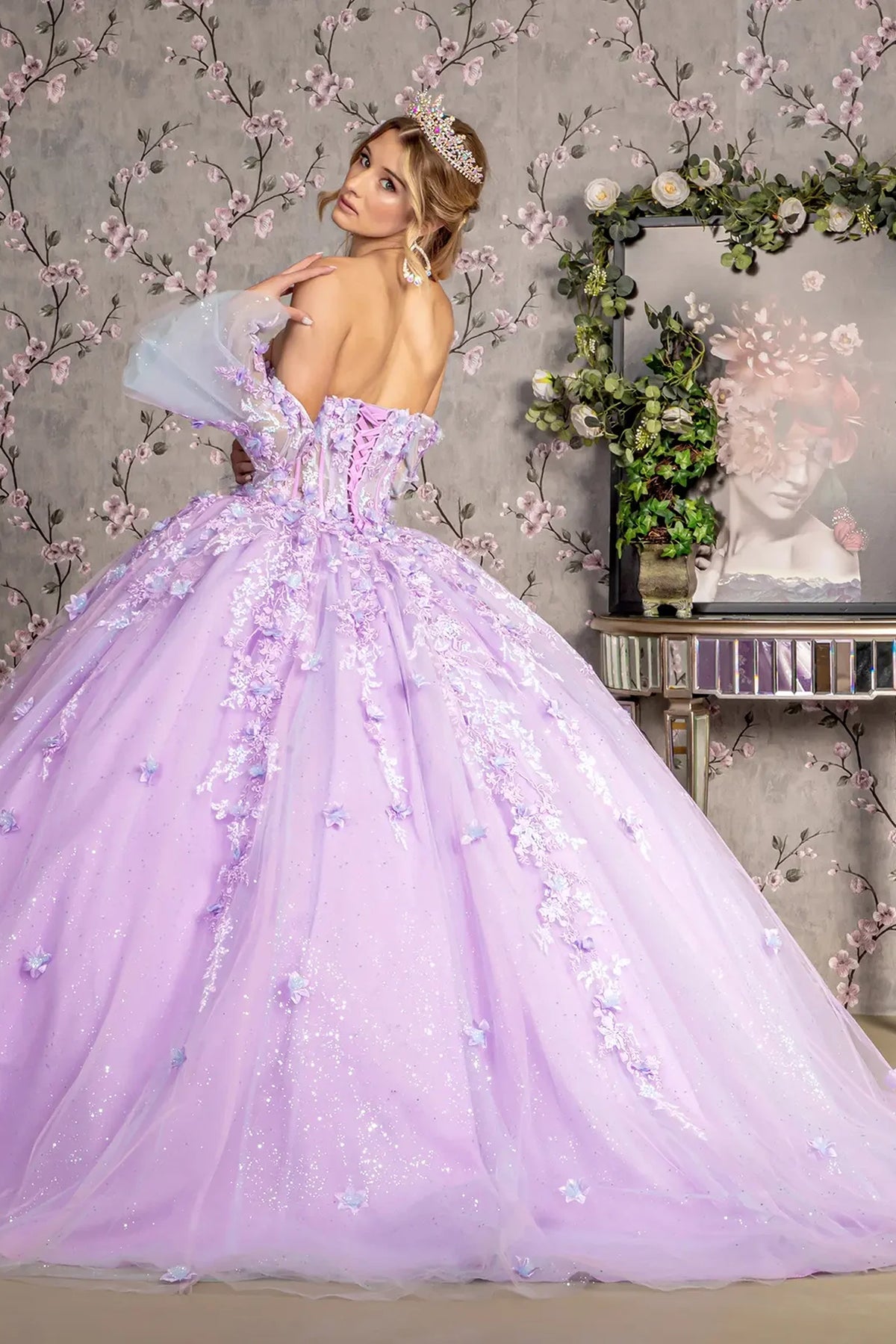 Layered skirt showcases the Lilac quinceañera ball gown with long trumpet sleeves.