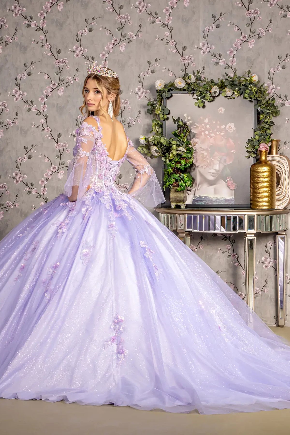 Layered skirt showcases the Lilac quinceañera ball gown with long sleeves.
