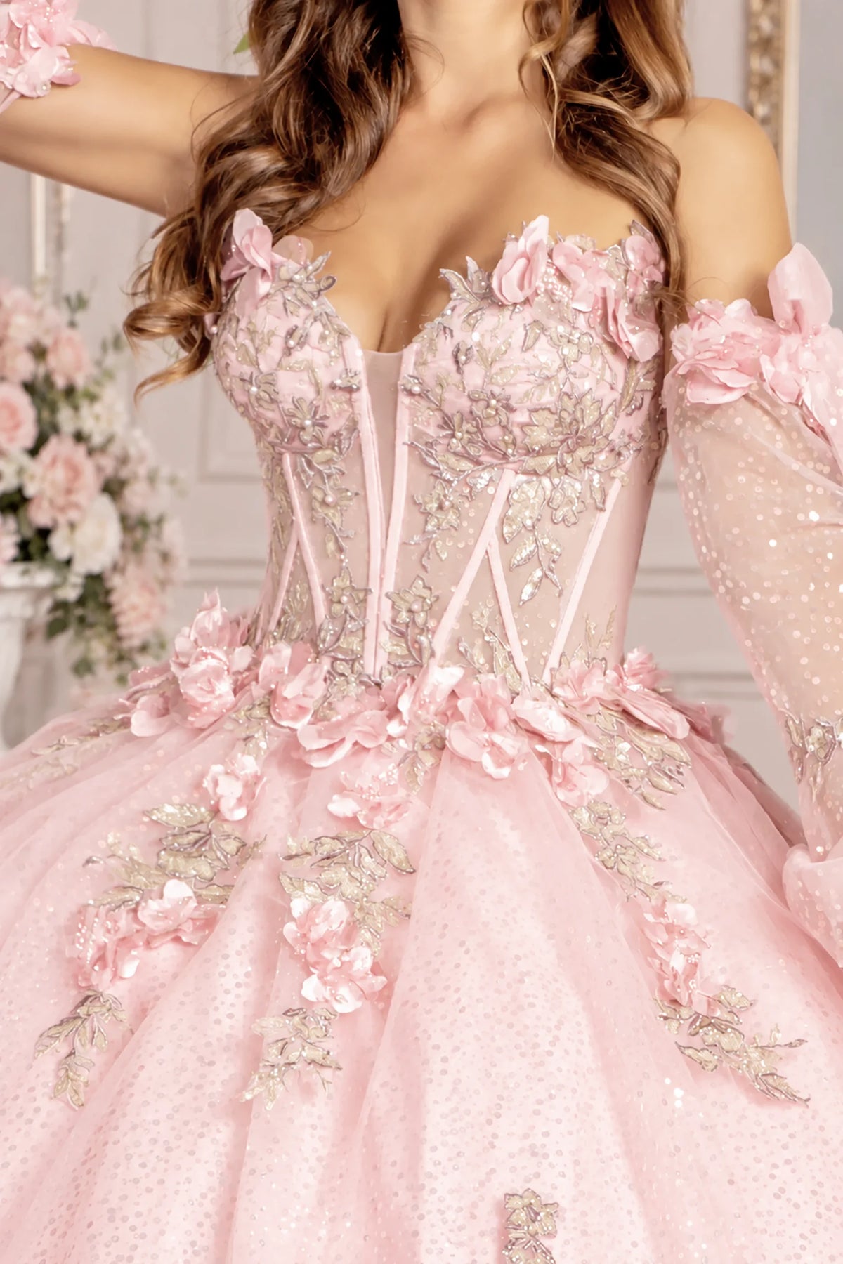 Close-up reveals the Blush quinceañera dress bodice with floral appliqués and illusion neckline