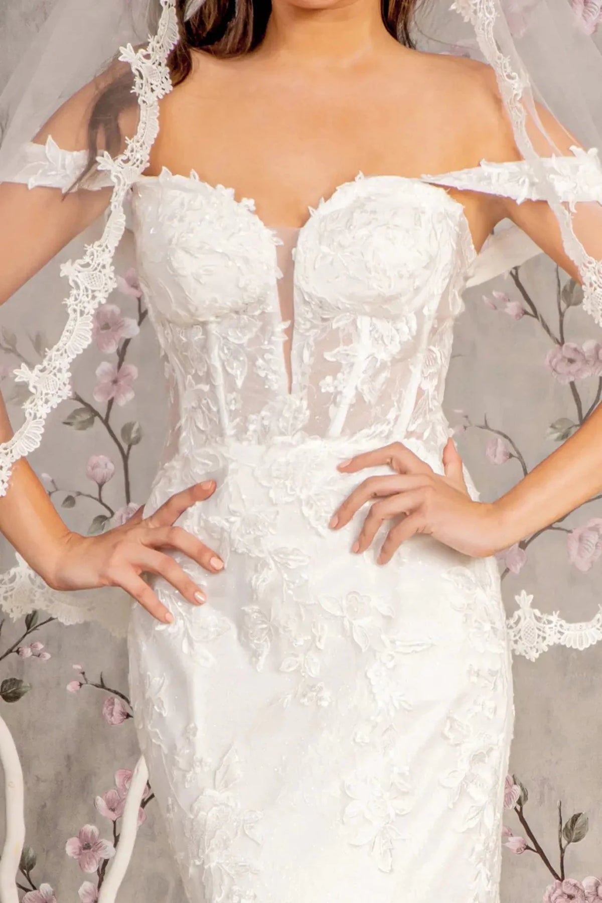 White wedding gown with floral embroidery on its sheer illusion sweetheart bodice.