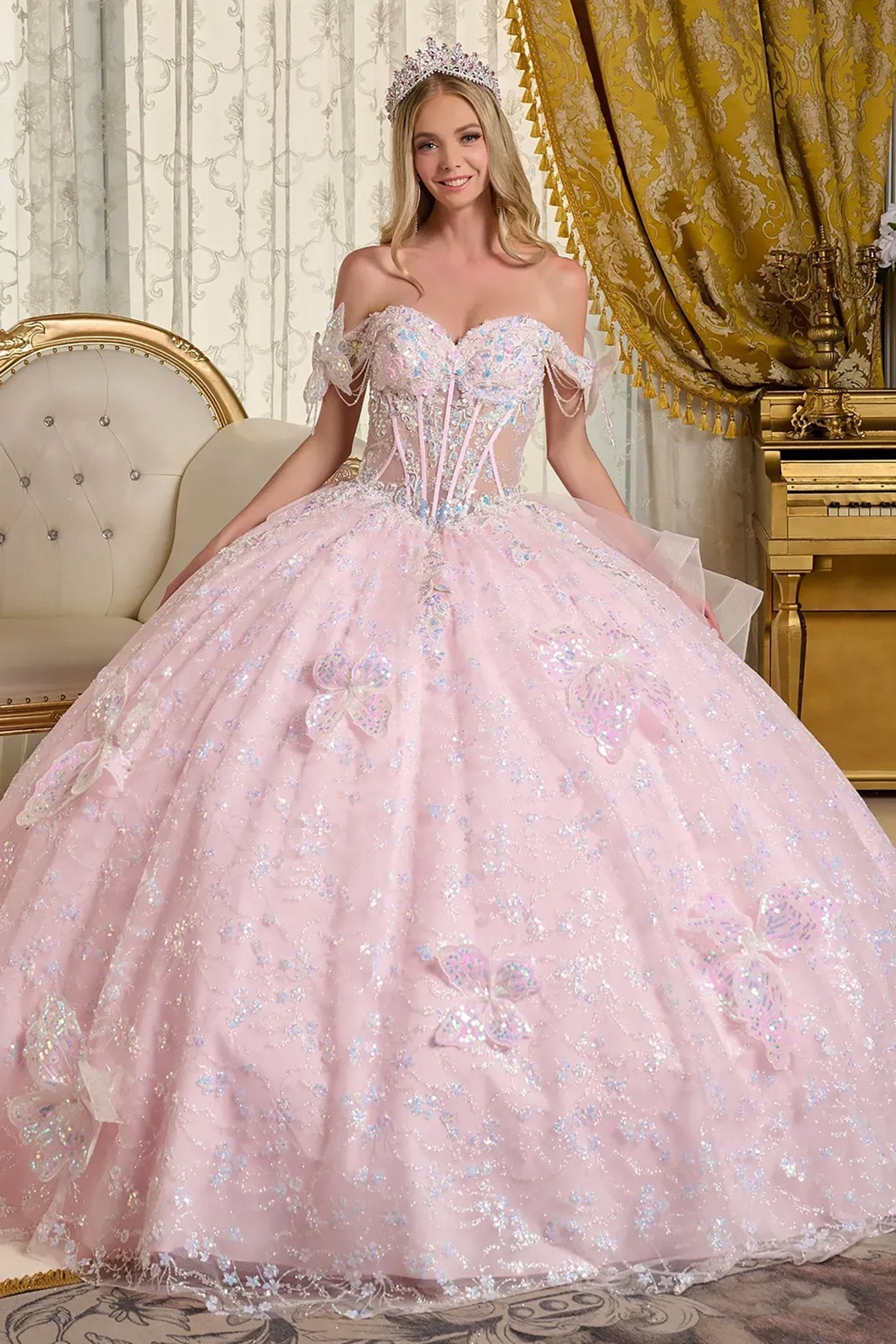 Woman in a pink quinceañera dress with floral details in an elegant room front view.