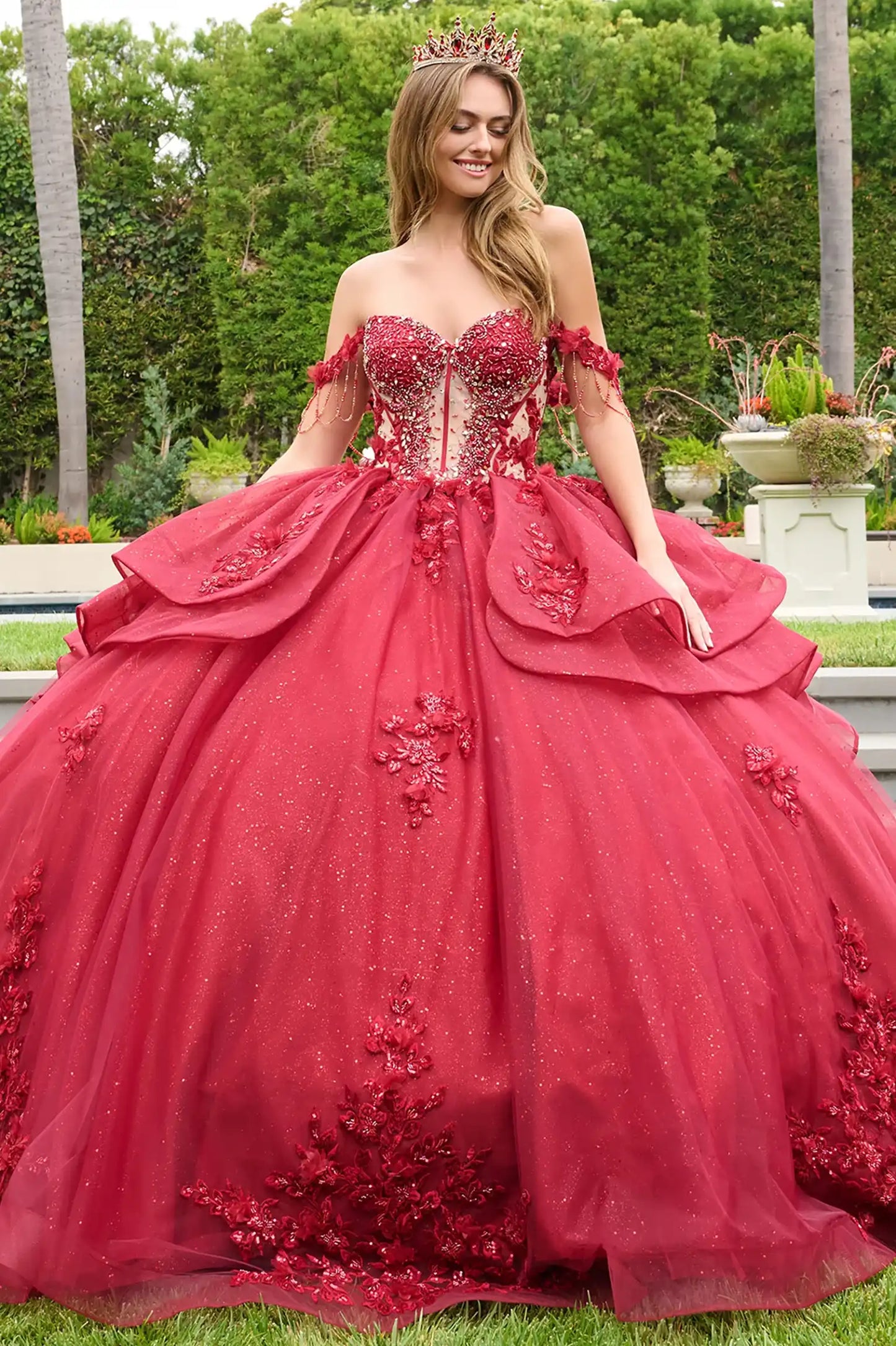 Red quinceañera ball gown with glitter mesh skirt, layered ruffled overskirt and accentuated waistline