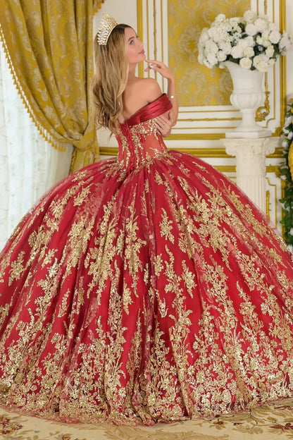 Woman wearing a red and gold quincenera ball gown in an elegant room.