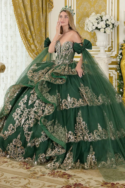 Woman in an elaborate green gown with intricate detailing in a decorated room.